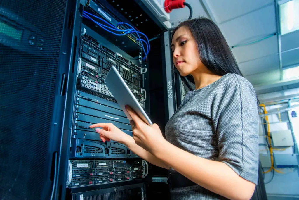 Technician inspecting server rack with tablet